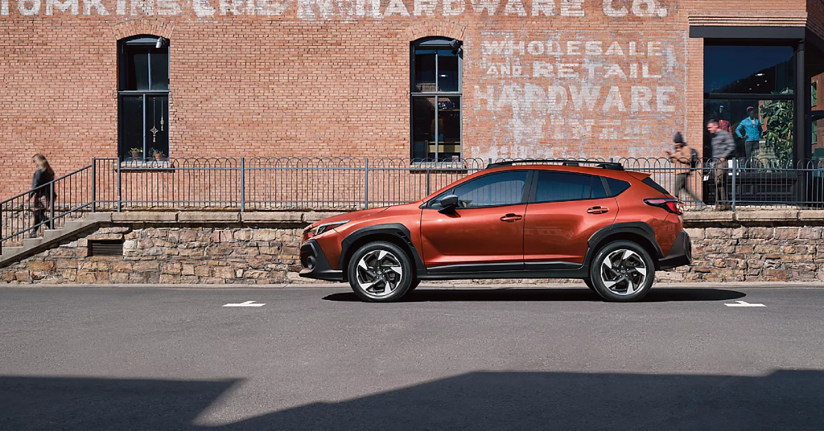 2025 Subaru Crosstrek Limited in Sun Blaze Pearl parked on the side of a building