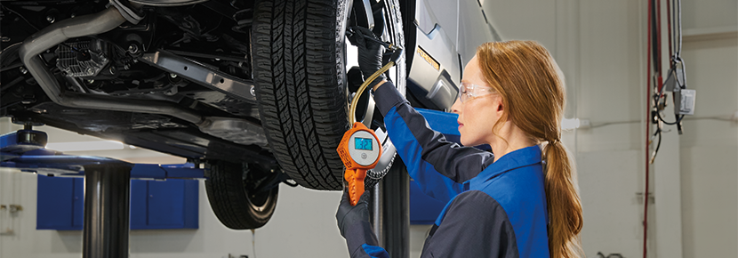 A Subaru technician checking tire pressure. | Sommer's Subaru in Mequon WI