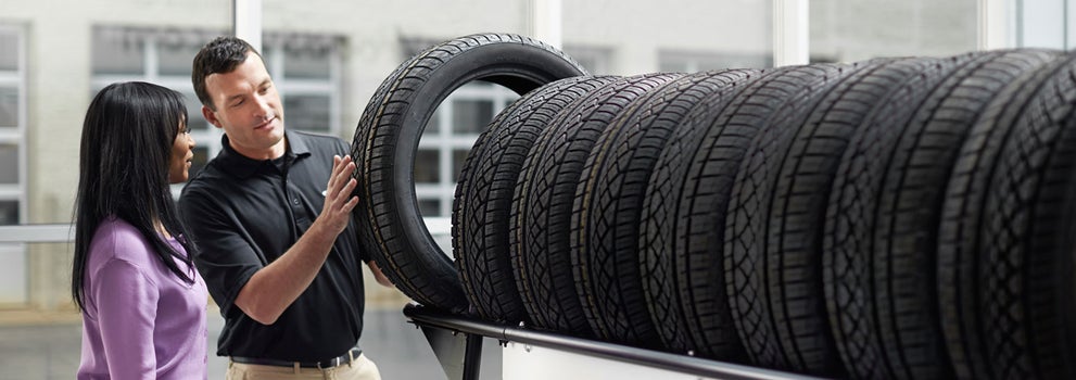 Subaru service representative showing customer a tire. | Sommer's Subaru in Mequon WI
