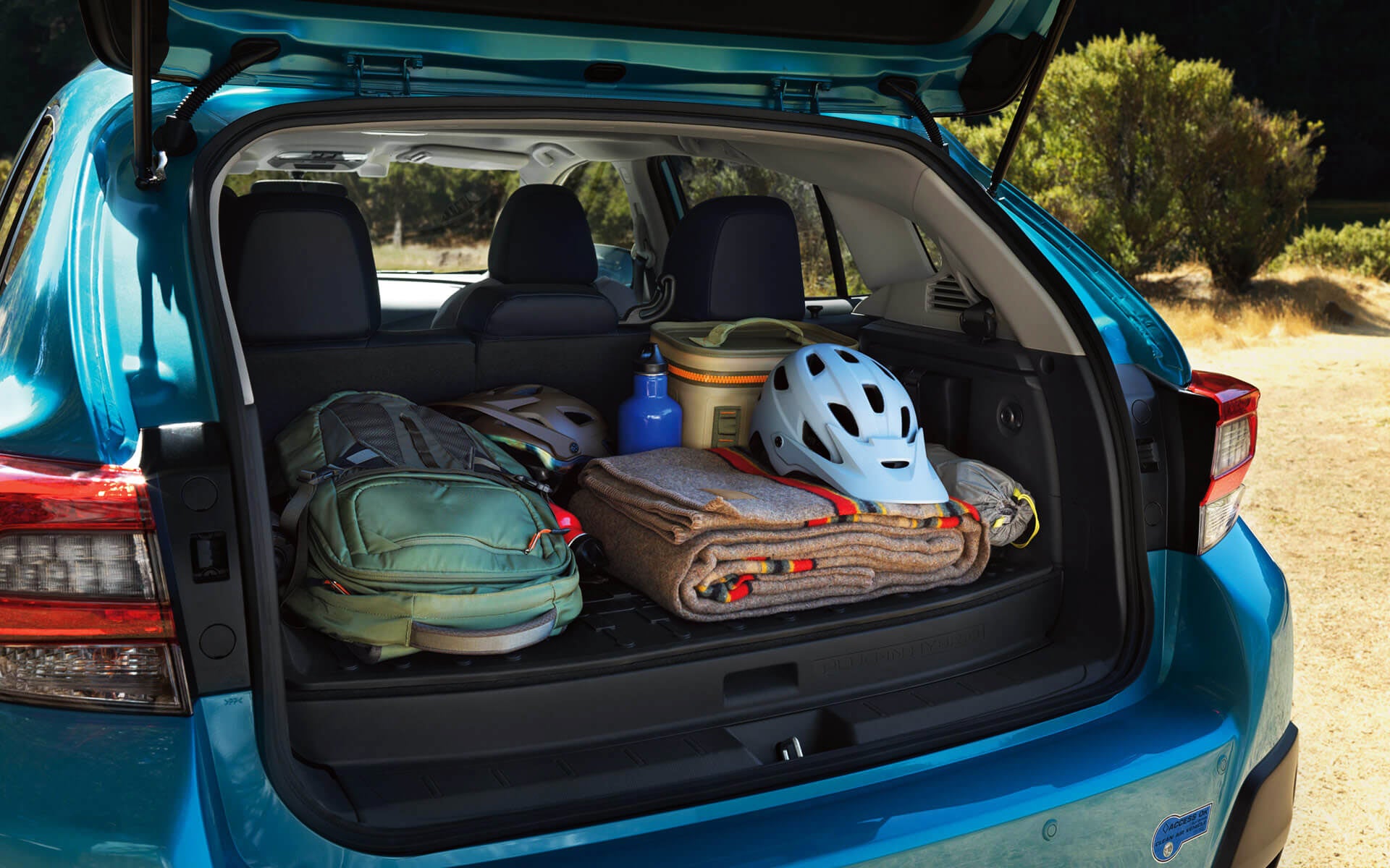 A backpack, blanket, and bike helmet in the rear cargo area of a Crosstrek Hybrid | Sommer's Subaru in Mequon WI