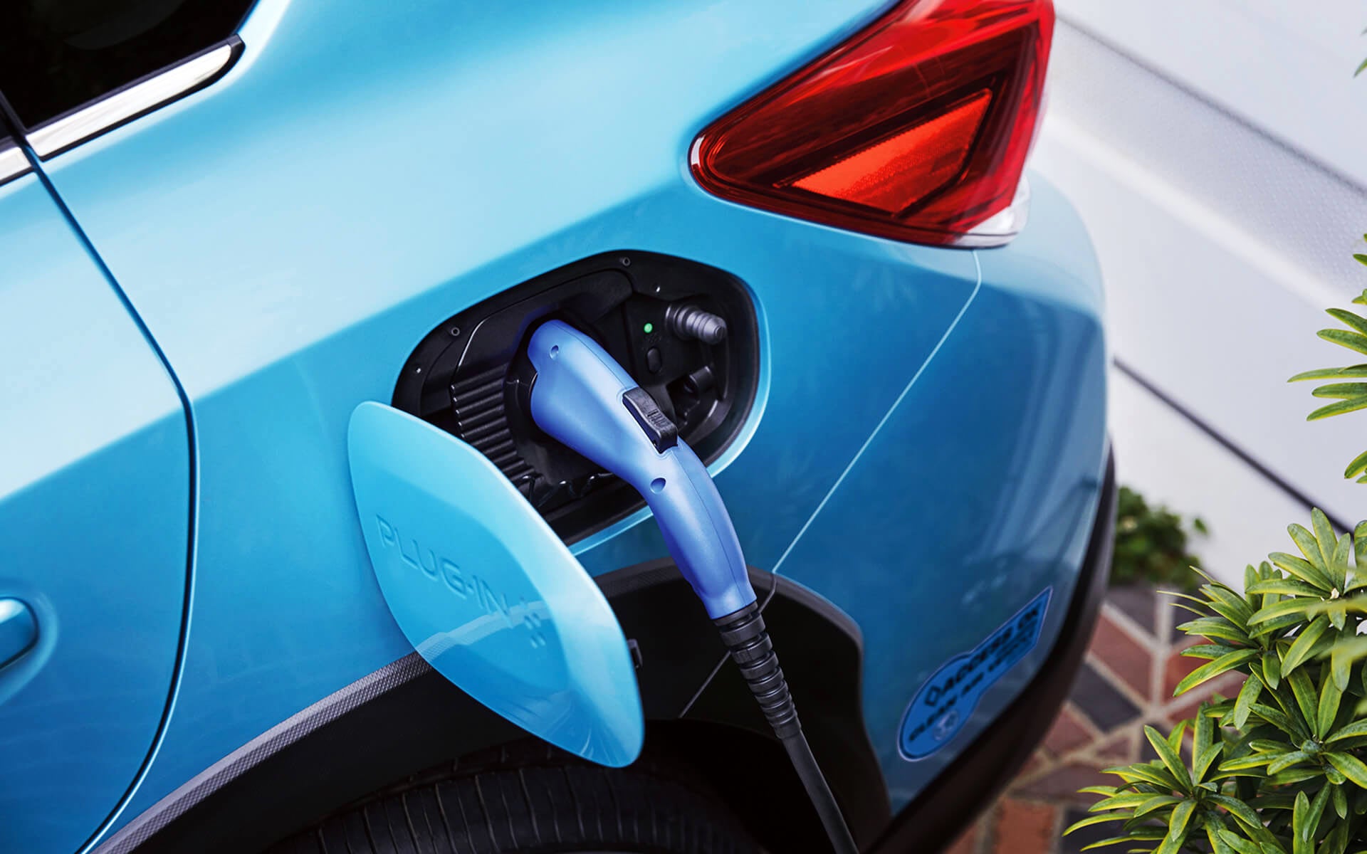 A close-up of the Subaru Crosstrek Hybrid's charging port with charging cable plugged in | Sommer's Subaru in Mequon WI